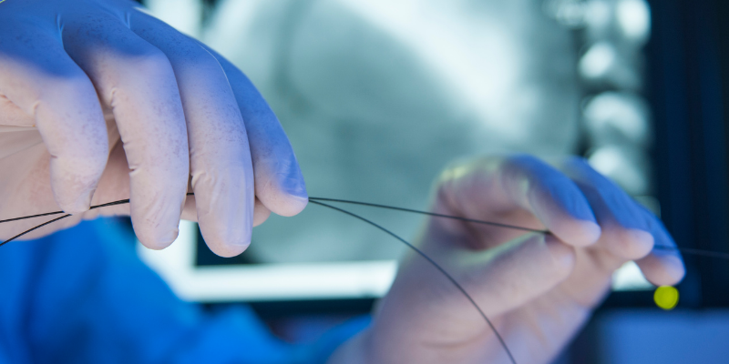 Gloved hands holding medical device