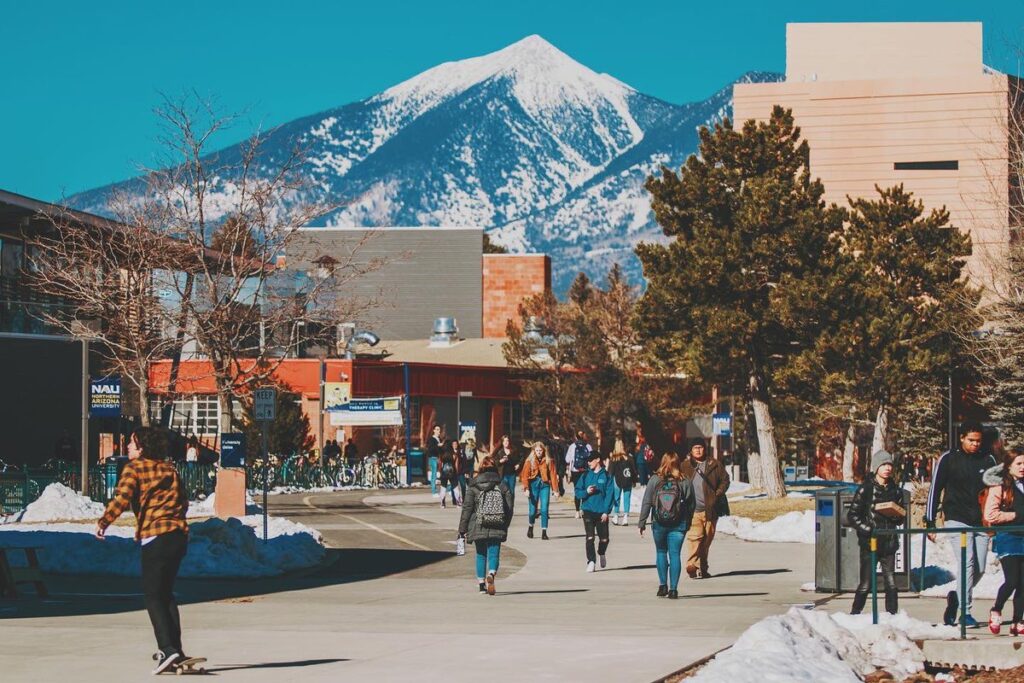 Students walking on NAU campus with mountains in background. NAU is currently working on a new master plan for the campus.