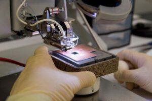 Closeup of hands working on semiconductor chip manufacturing